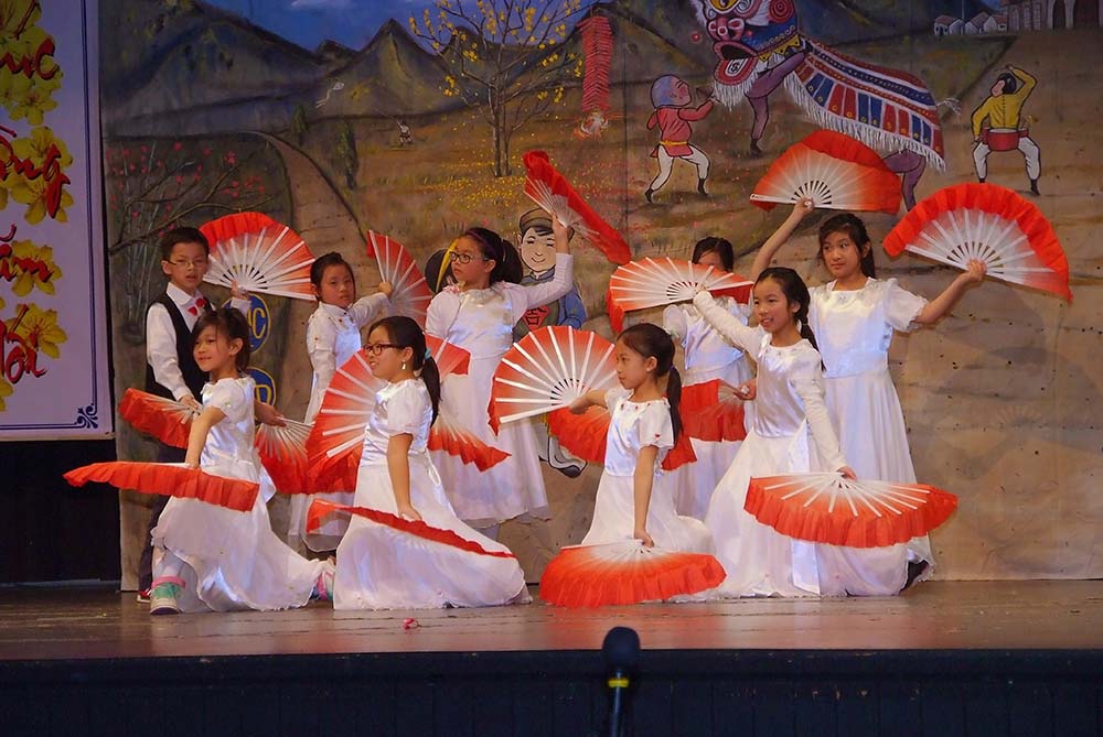 Students dressed in traditional clothing and performing on stage for the Chinese Lunar New Year
