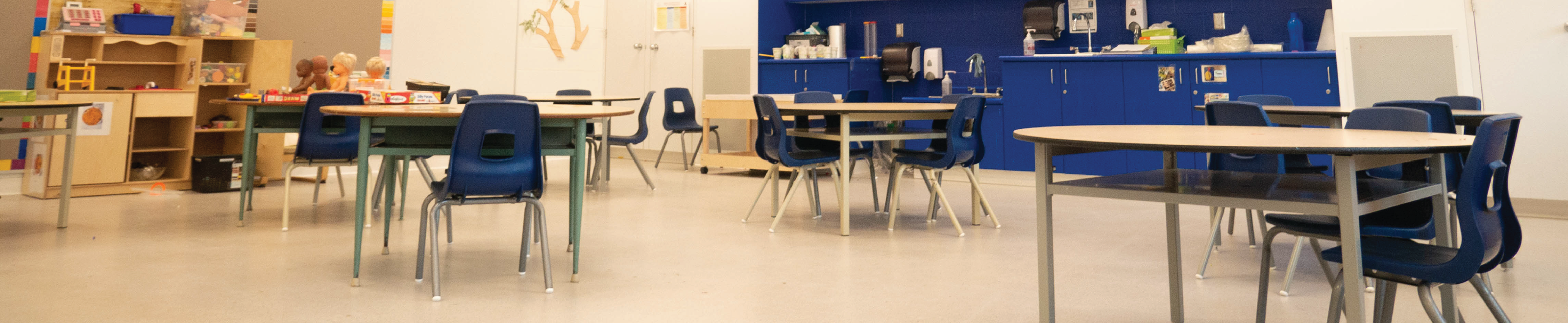 An empty classroom with chairs and tables.