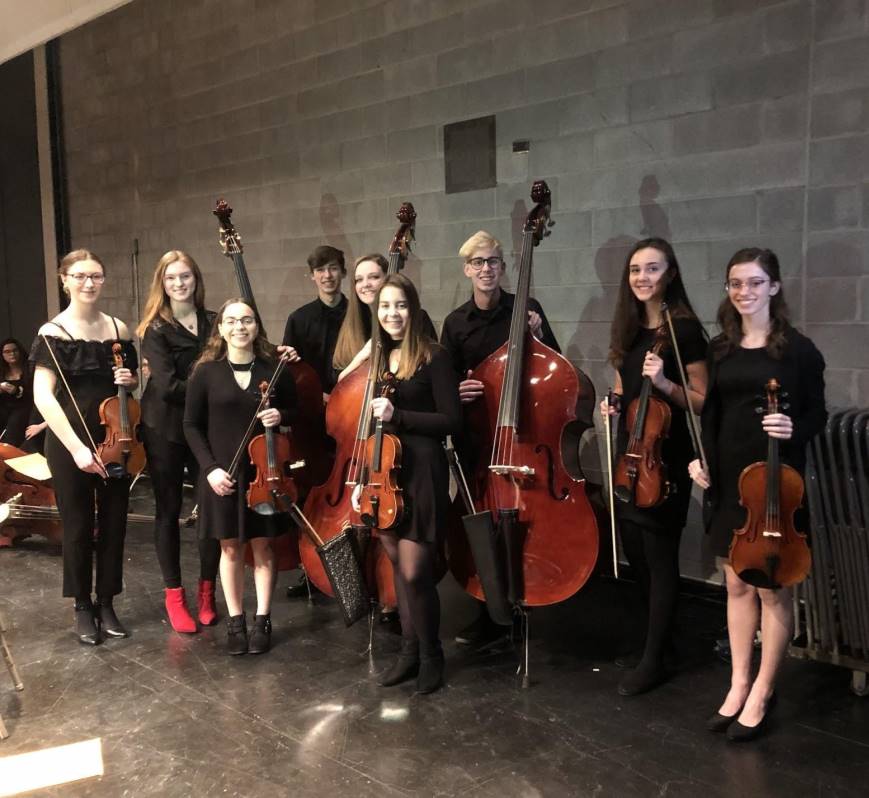 Music students in formal wear holding their string instruments