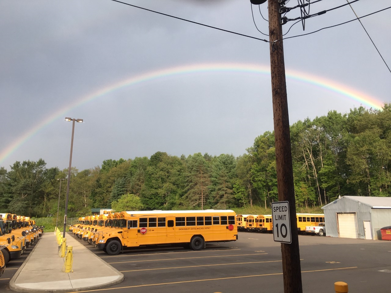 The bus yard with a rainbow in the sky