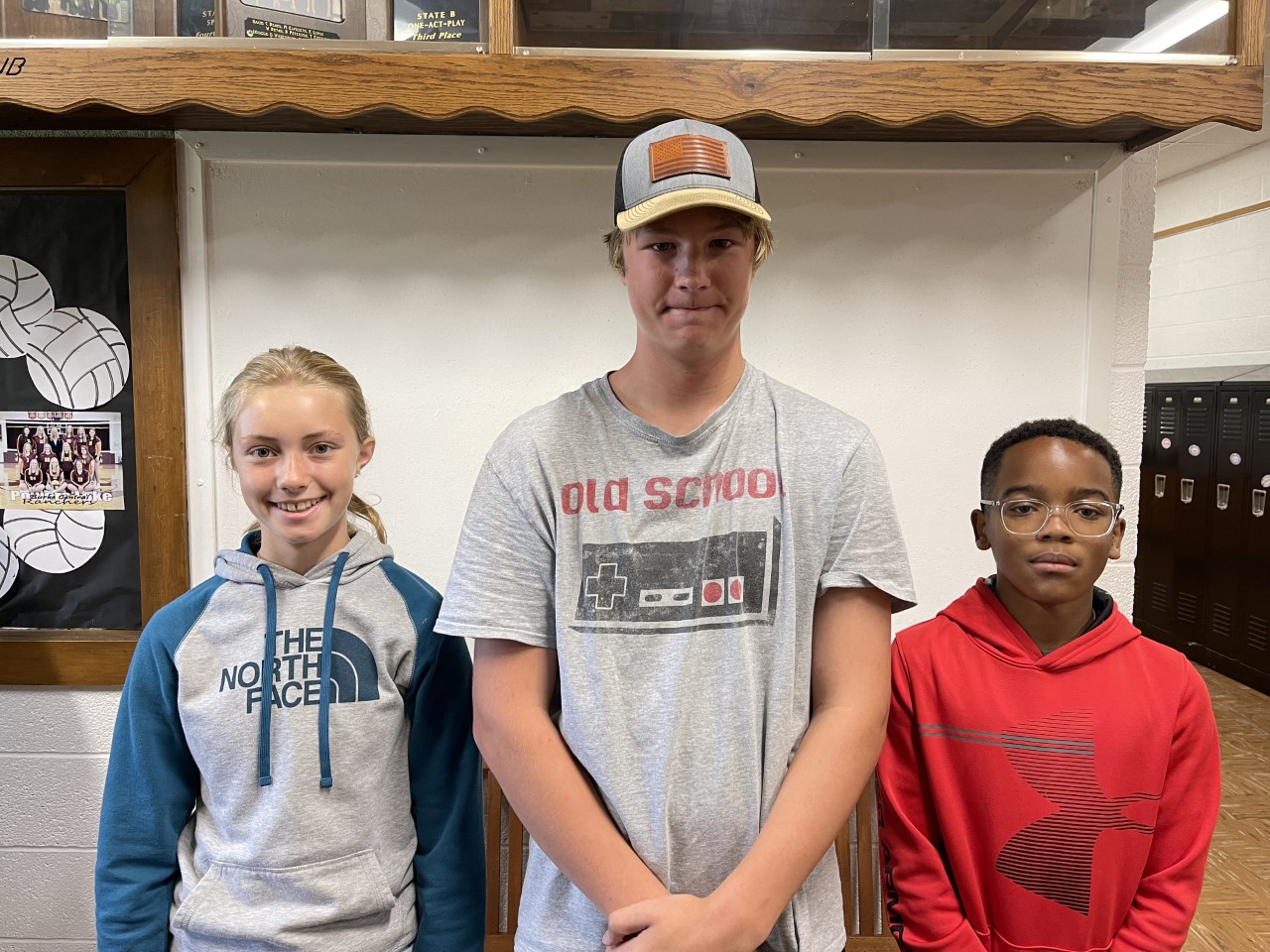 3 students standing in front of white board