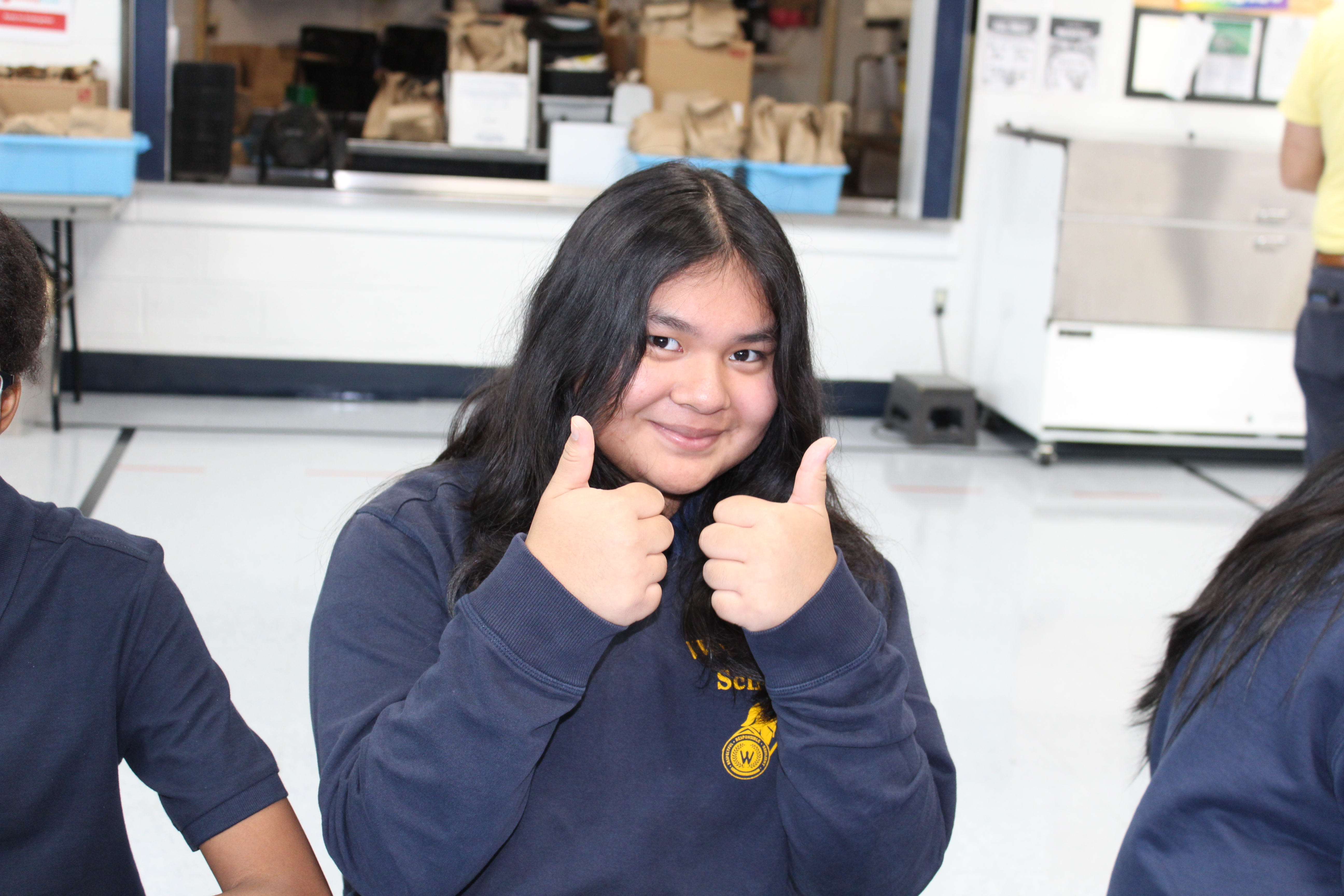 student holding two thumbs up