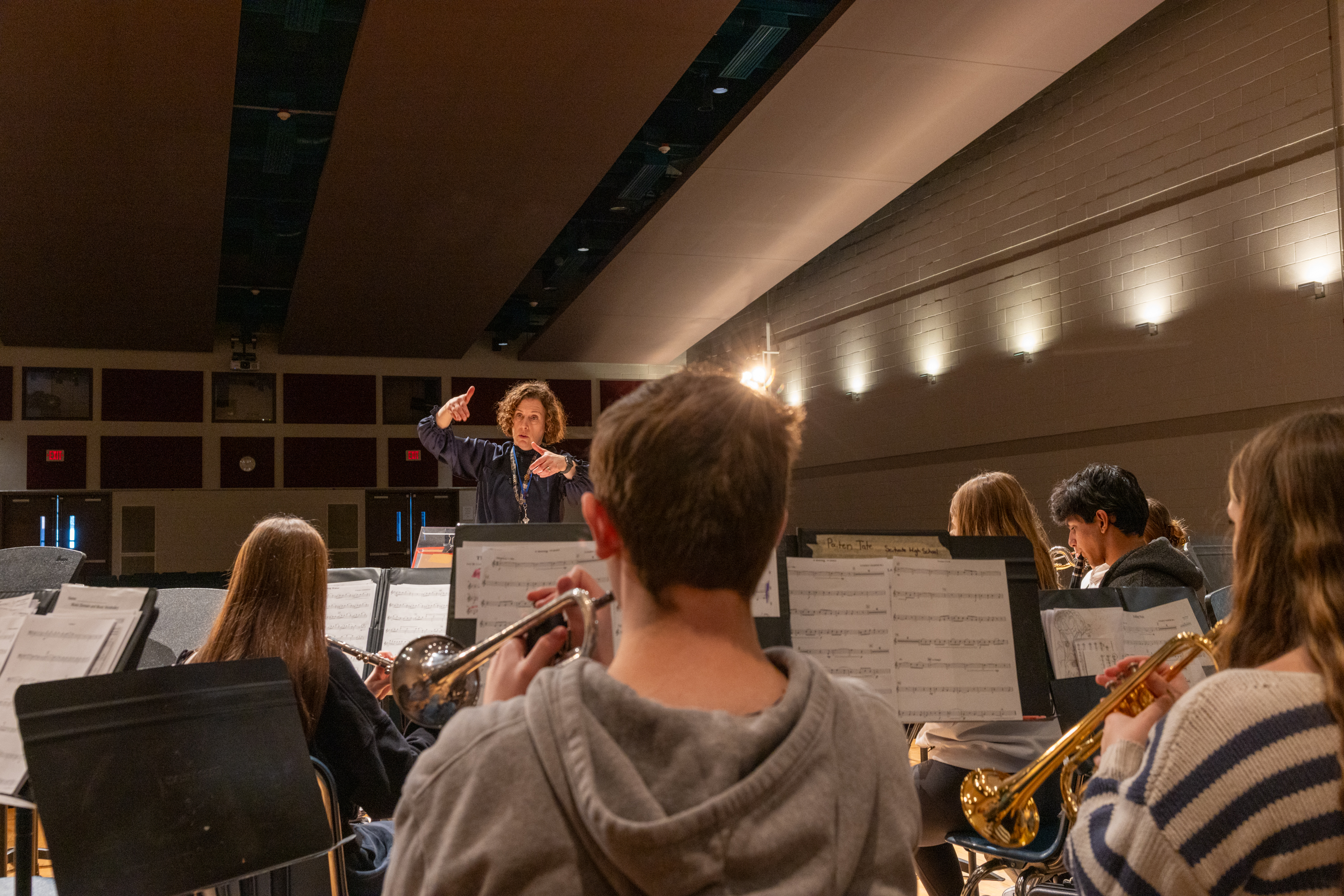 Band director leads students through a rehearsal in the auditorium