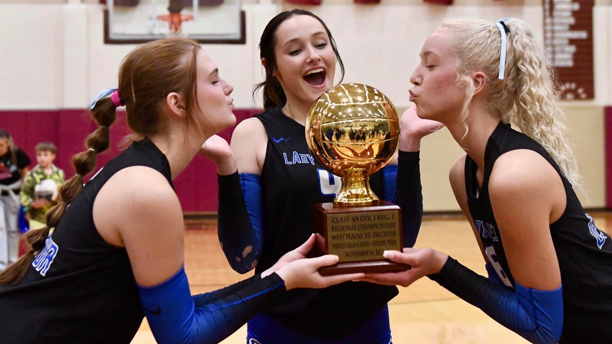 Lady Volleyball student athletes keys a newly-won trophy