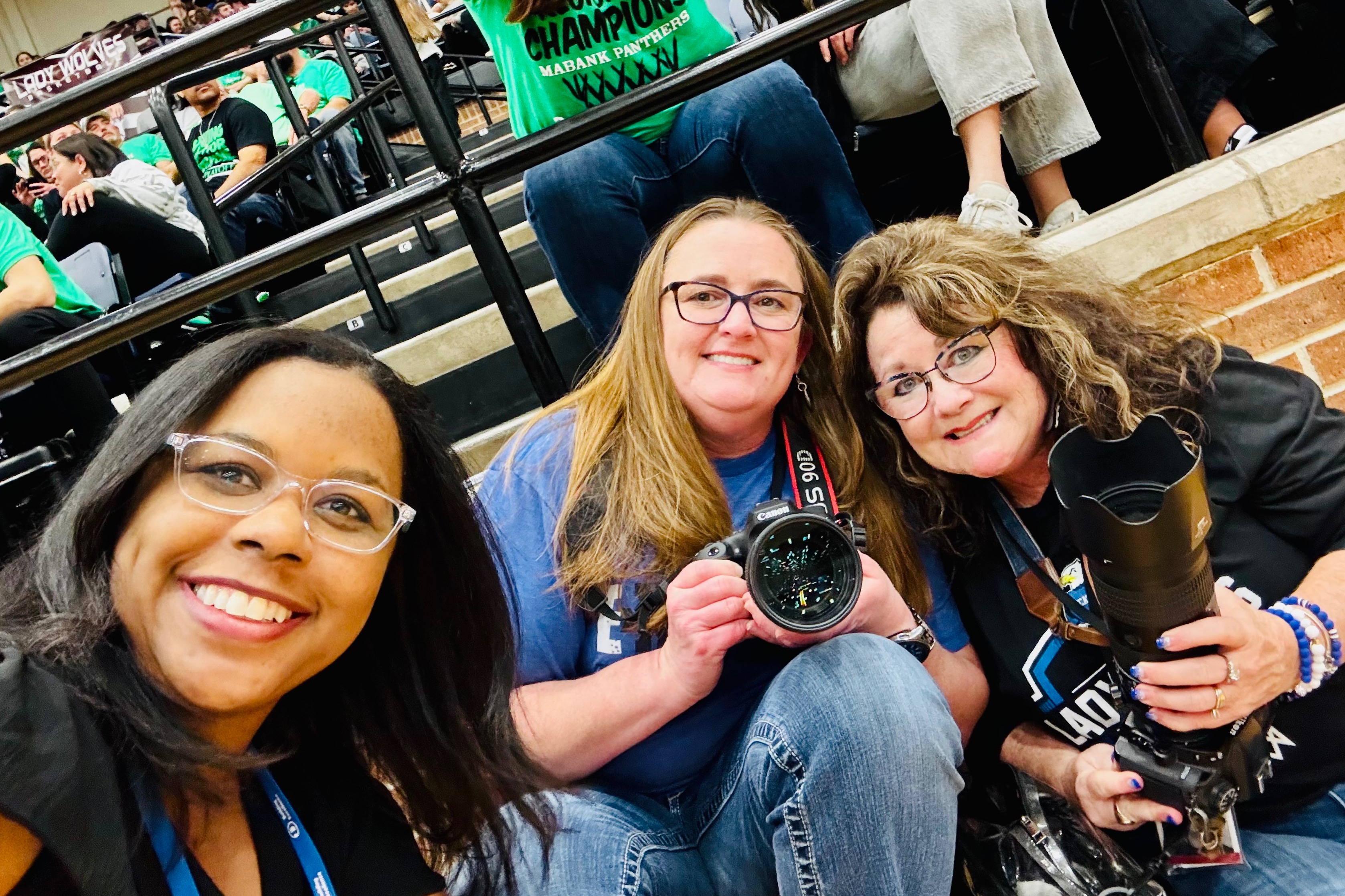 Photo of three photographers smiling at a game 