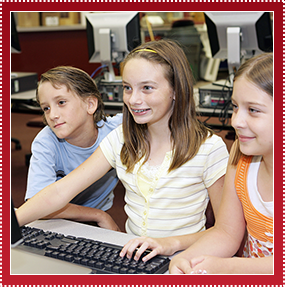 Three kids looking at a computer