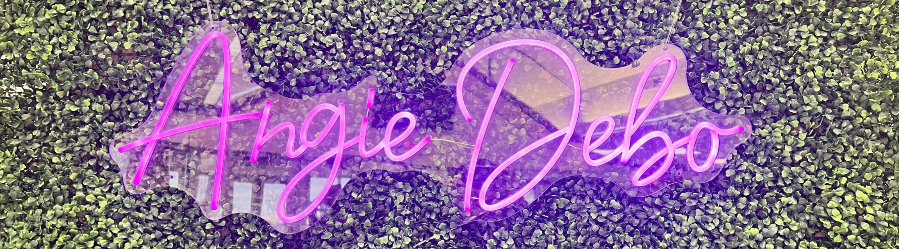 Purple Angie Debo Neon Sign On Artificial Box Hedge