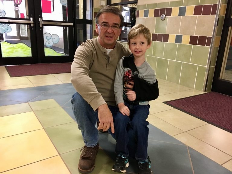 parent and young student posing for picture in hallway