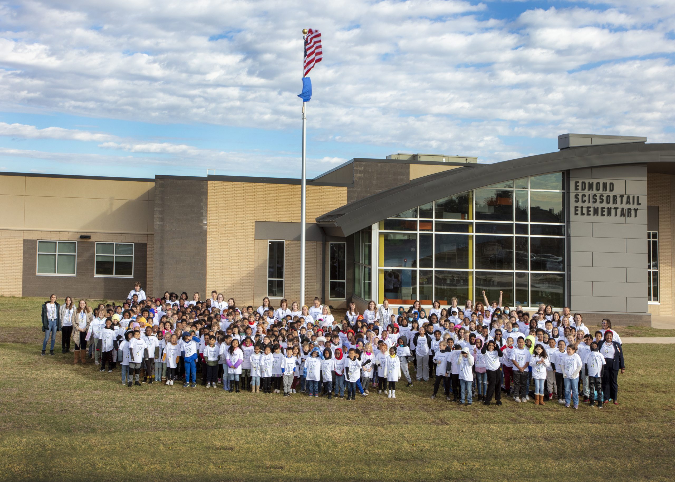Elementary students around the flag pole