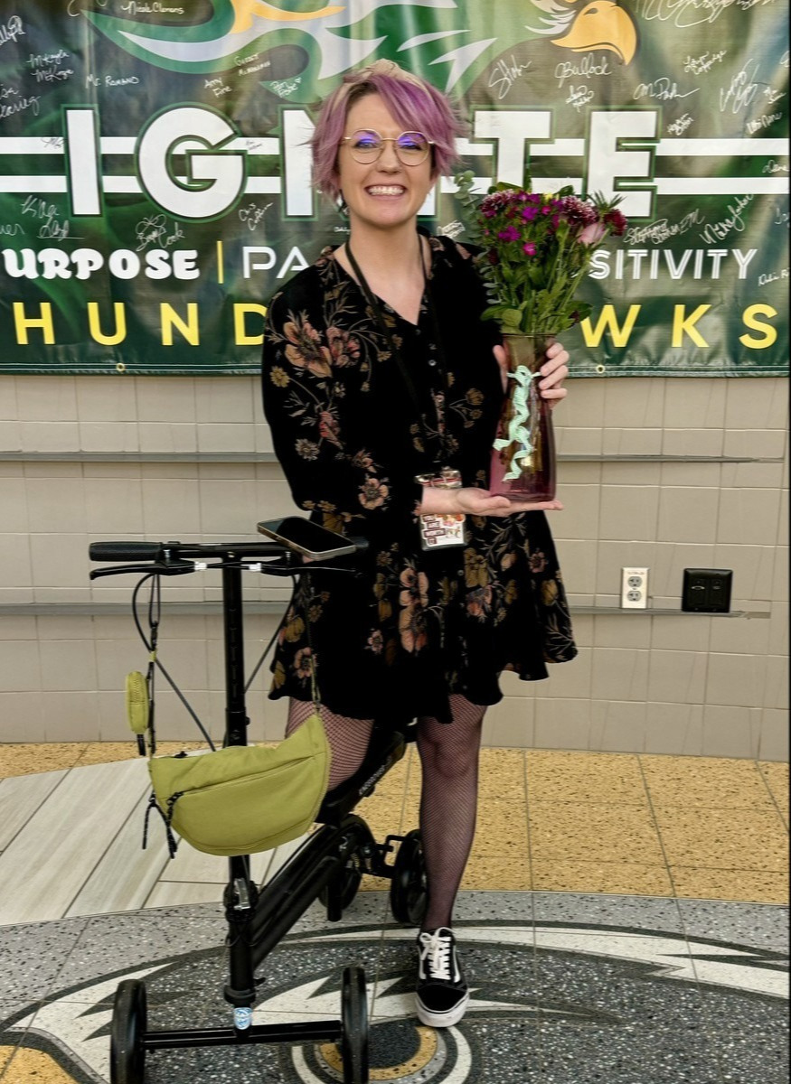 Bri Akins, a classroom assistant at Heartland Middle School, smiles for a picture while holding flowers after being awarded Support Employee of the Year .