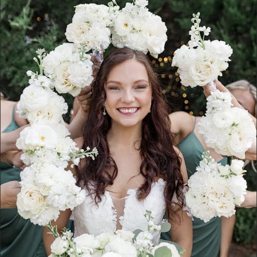 Mrs. Williams in her wedding dress with flowers around her