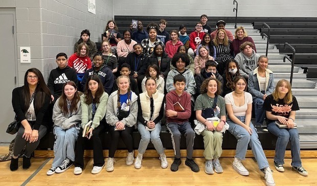 Summit students pictured sitting in bleachers at the author visit event where they heard from book author, Jennifer Neilsen.