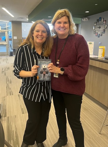 Summit librarian, Kathy Williams, pictured holding a book while standing beside book author, Jennifer Nielsen, at the author visit event.