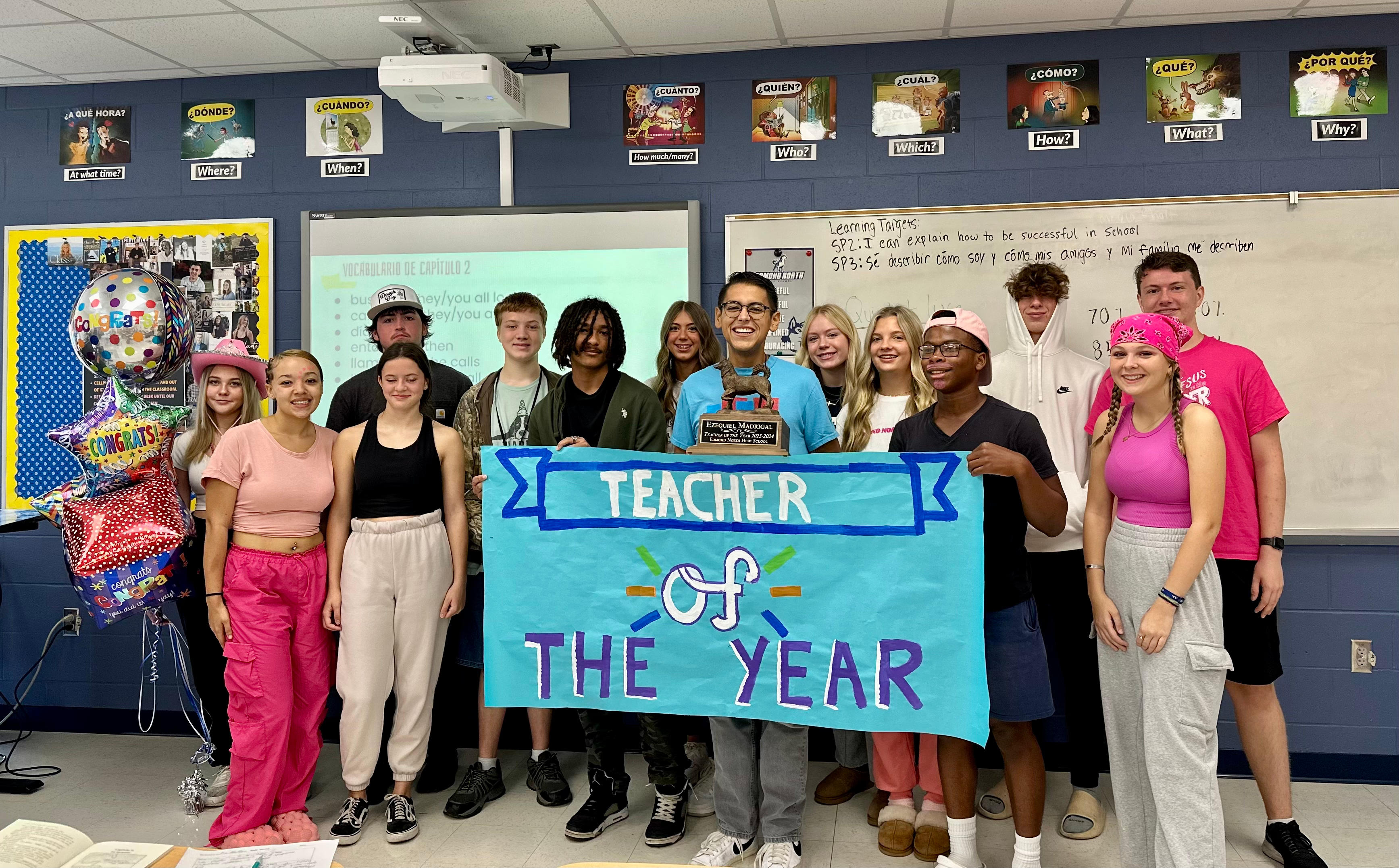 Students and teachers, featuring Teacher of the Year Ezequiel Madrigal, gather for a group photo in the classroom.