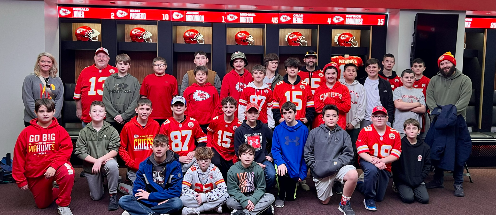 middle schoolers stand in front of cubbies in the Chiefs locker room