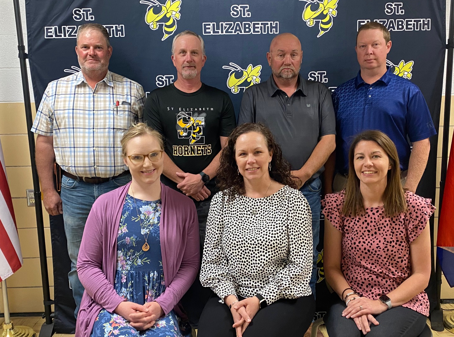 Six school board members posing in front of school