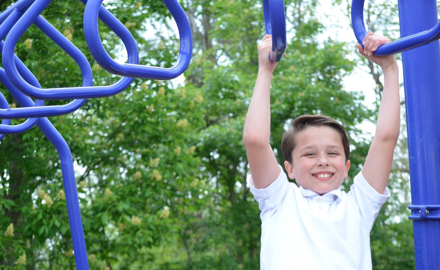 Smiling student on the monkey bars