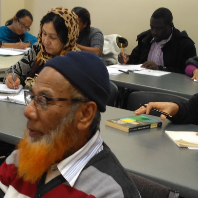 adult ESL class attendees in class taking notes
