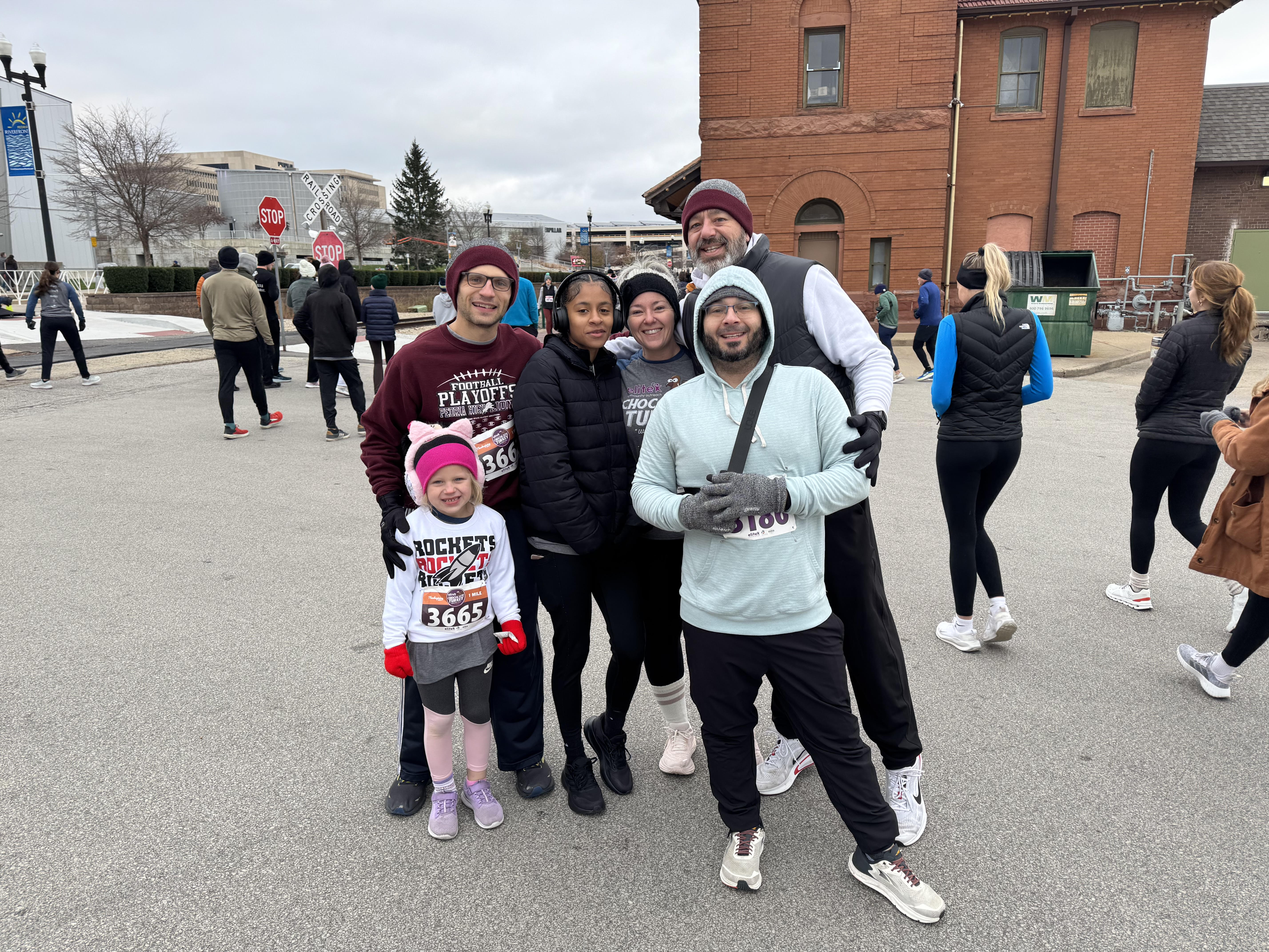 L-R: Kyle Daubs and his daughter Penelope, Allannah Williams, Dana Sandrers, Jeff Roper, and Dan Clemens get ready to run downtown Peoria at the Chocolate Turkey