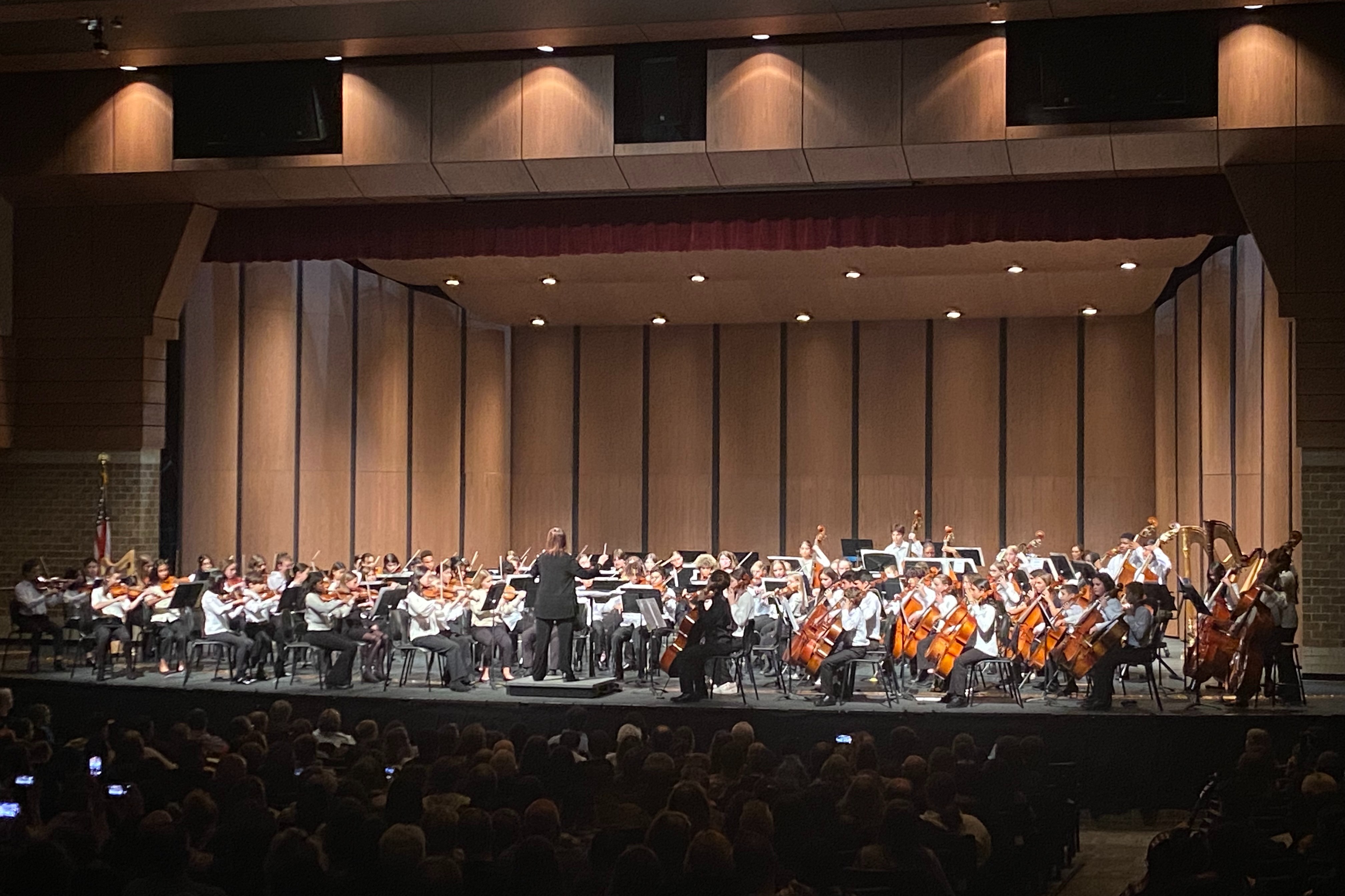 students play in orchestra on stage