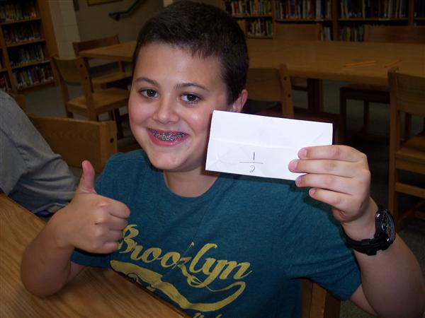 image of kid doing thumbs up holding a paper with numbers