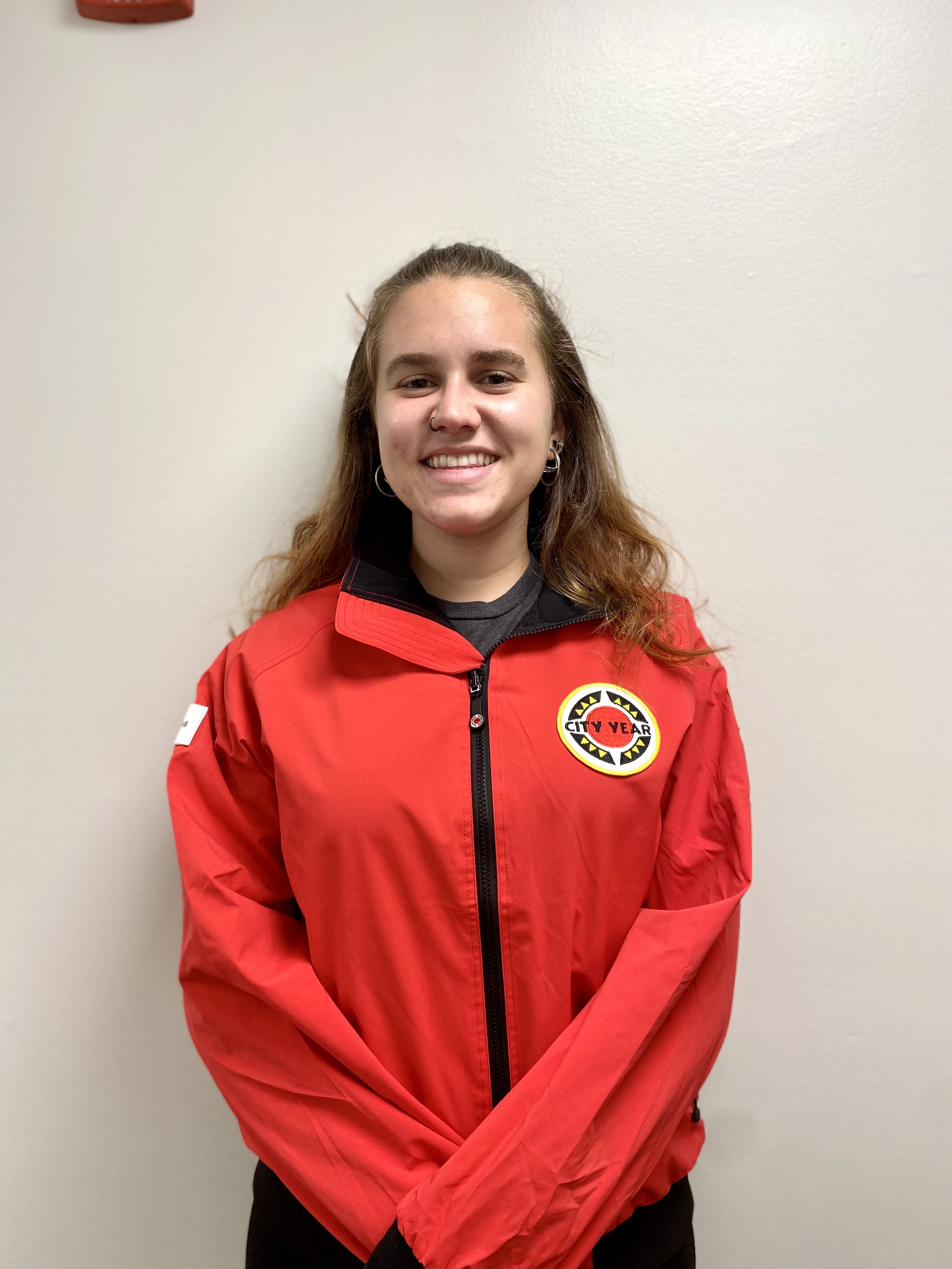Light-skinned woman with brown hair wearing red City Year jacket