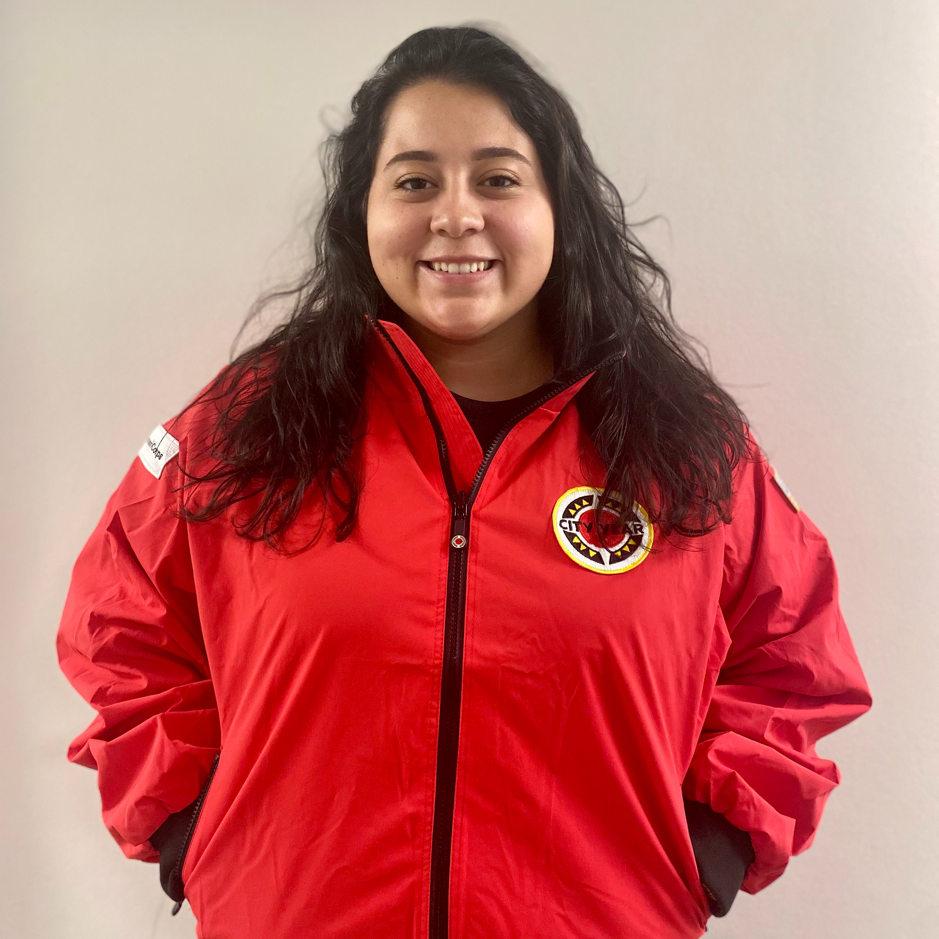 Woman with dark hair wearing red City Year jacket