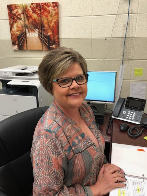 Principal - Cheryl Holland sitting on desk