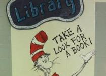 library sign with cat in the hat that says take a look for a book