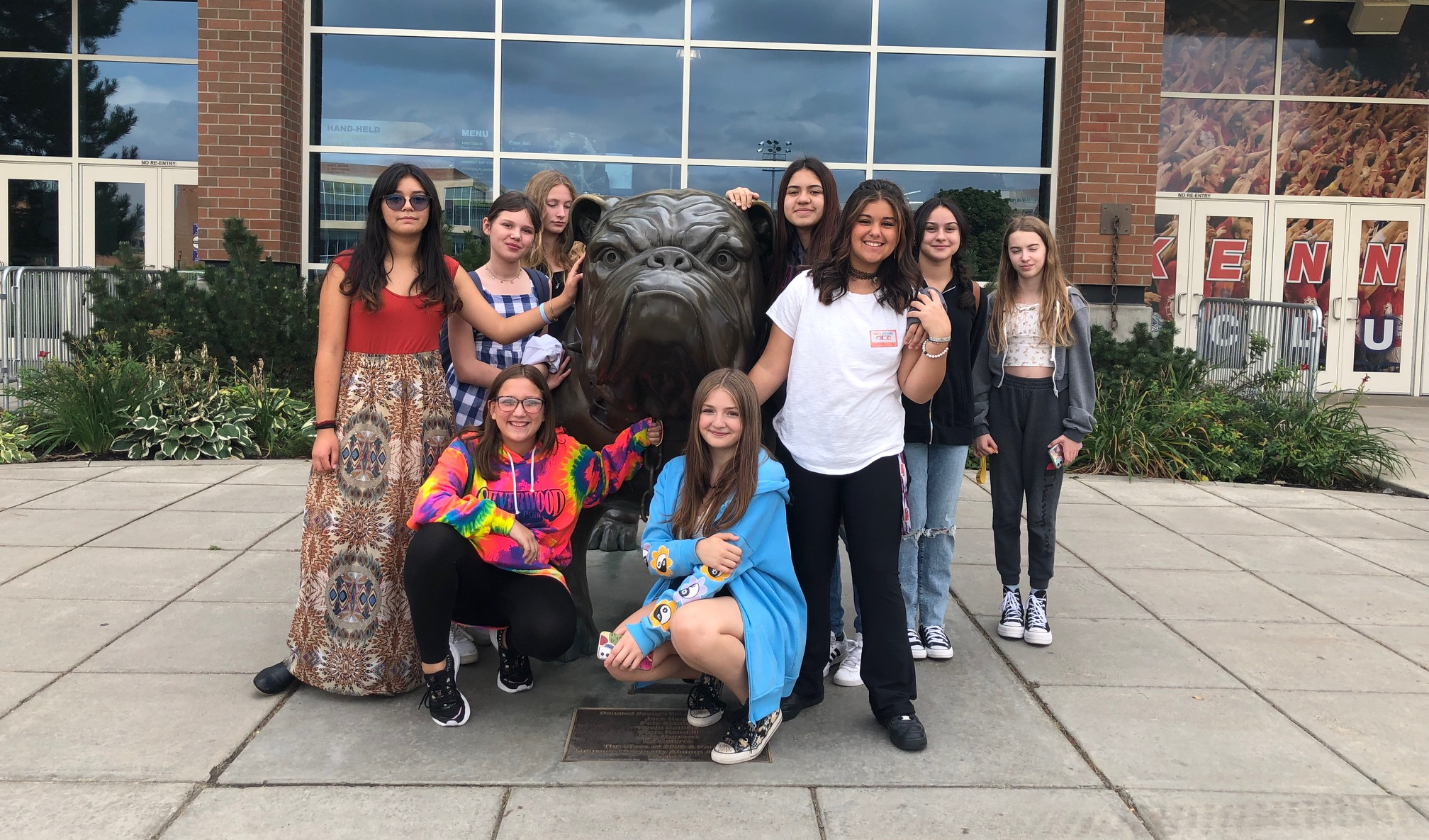 Students posing in front of bulldog statue