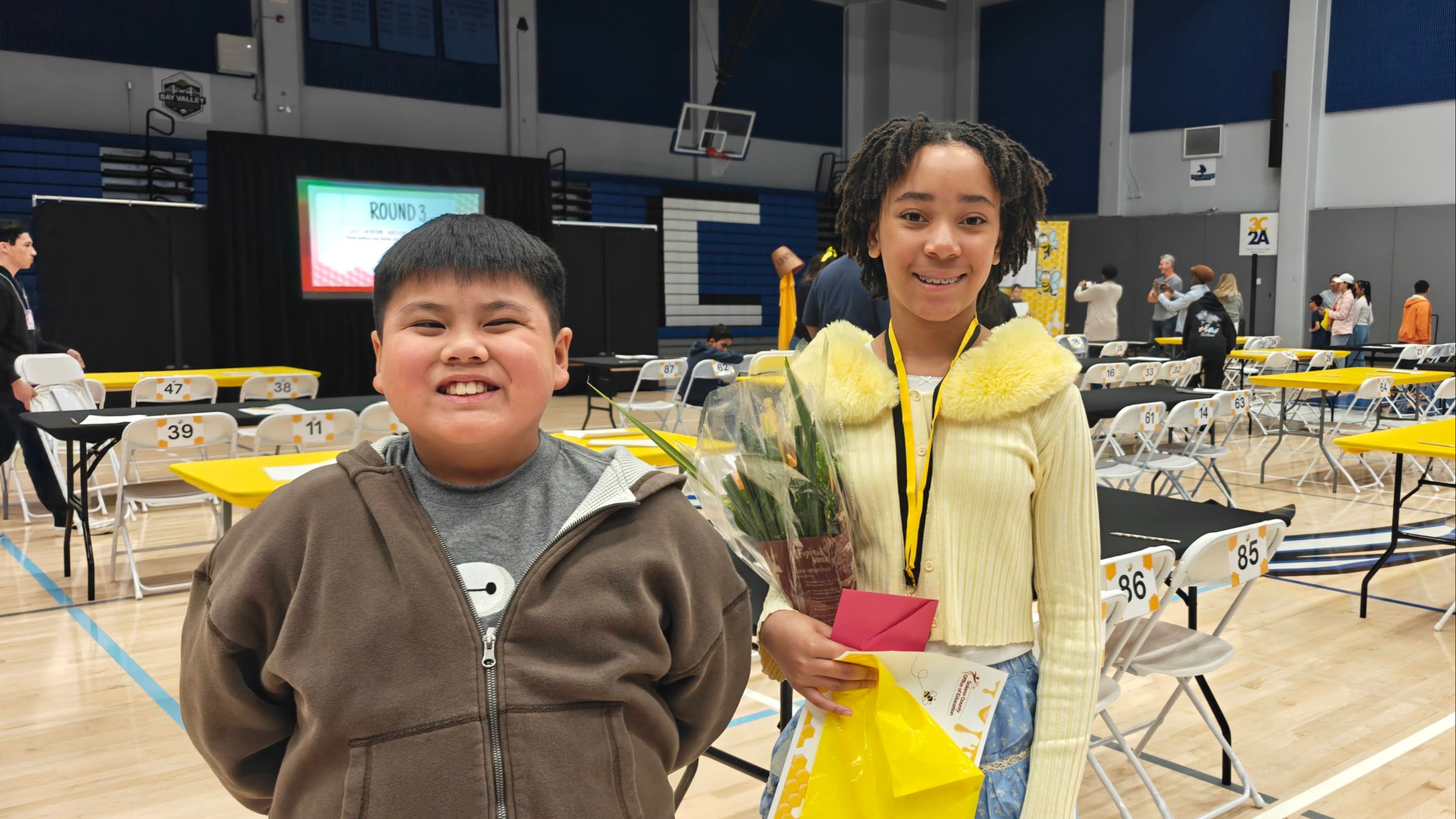 Two students smiling after participating in a spelling bee