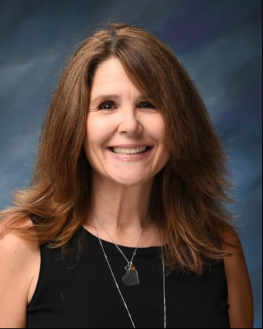 Portrait of a smiling Susan Owens with long brown hair against a dark blue and purple background.