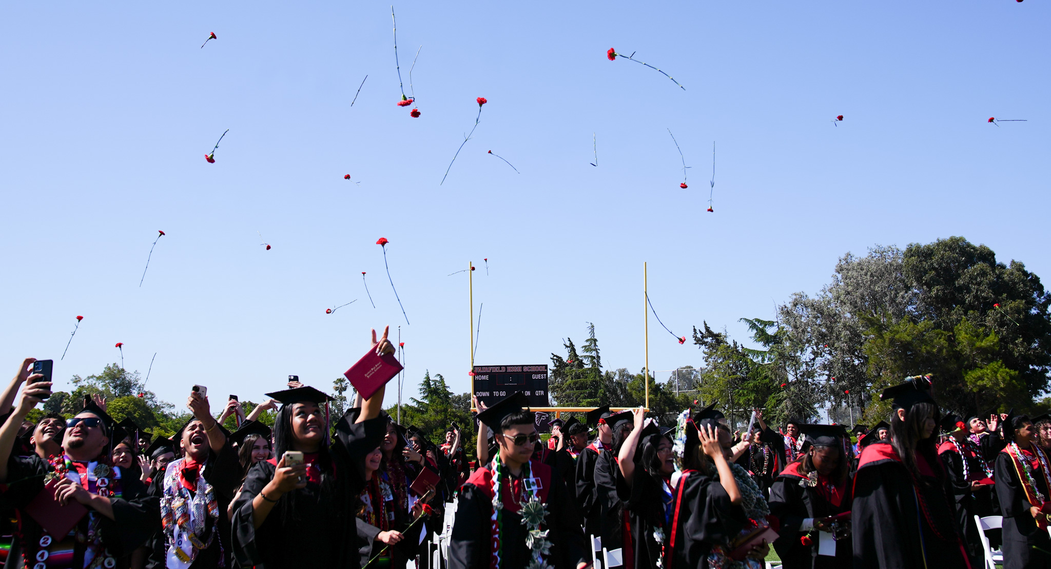 Graduates throwing flowers in the air