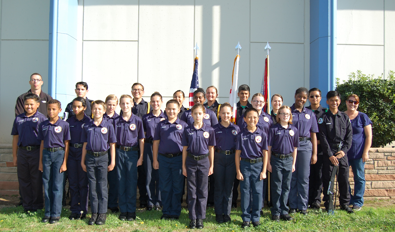 A group of young cadets in front of the American flag