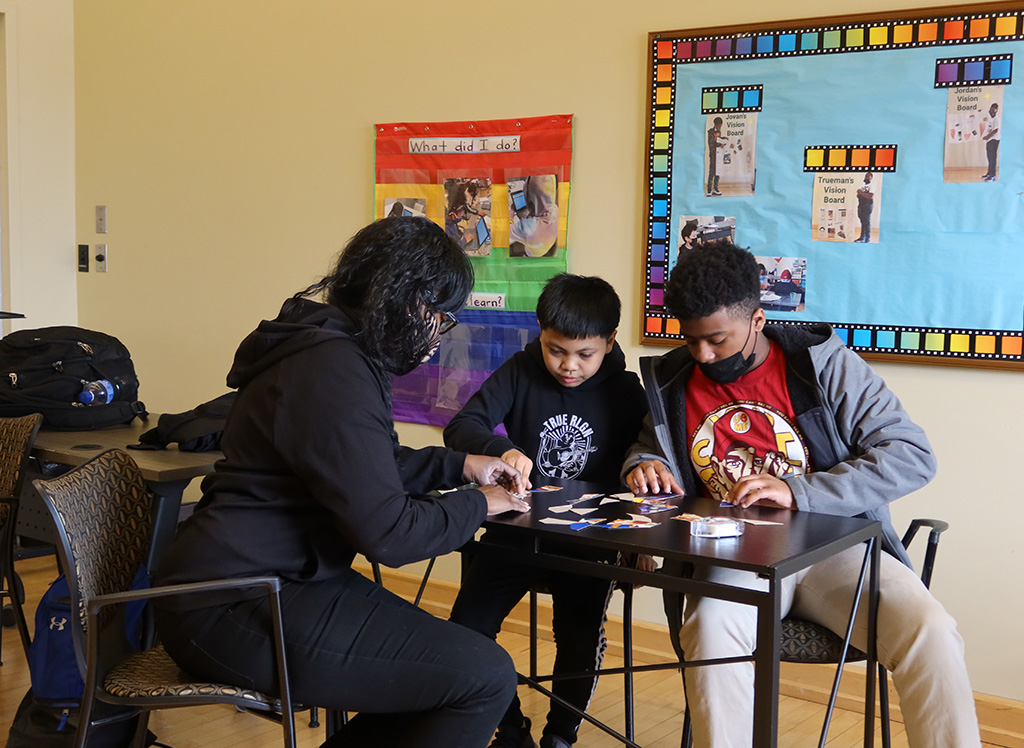 students huddled over table working on project