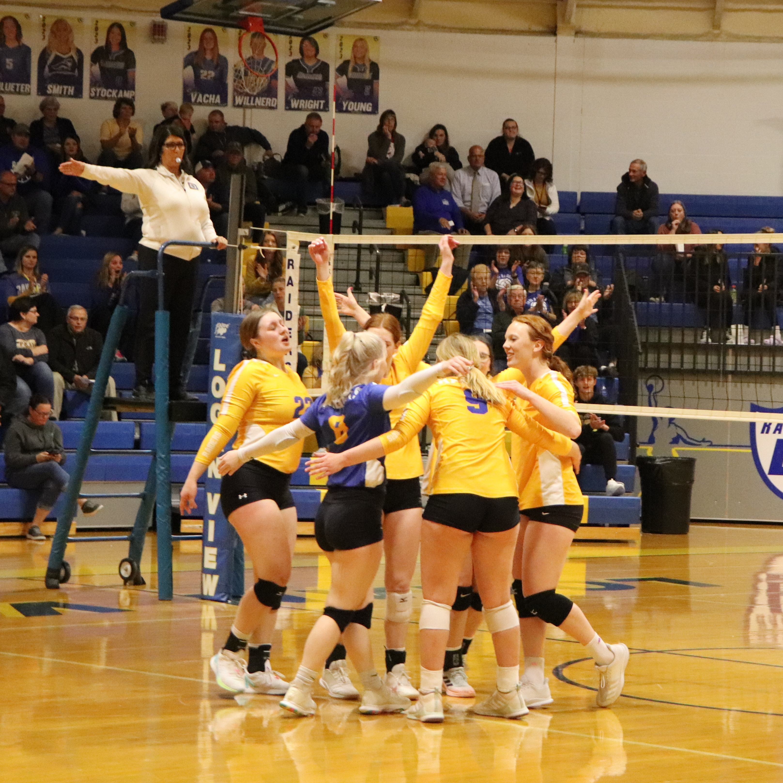 volleyball girls cheering by  the net after a side out
