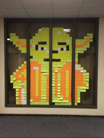 a picture of Yoda from Star Wars, replicated by sticky notes on a window in the Logan View building