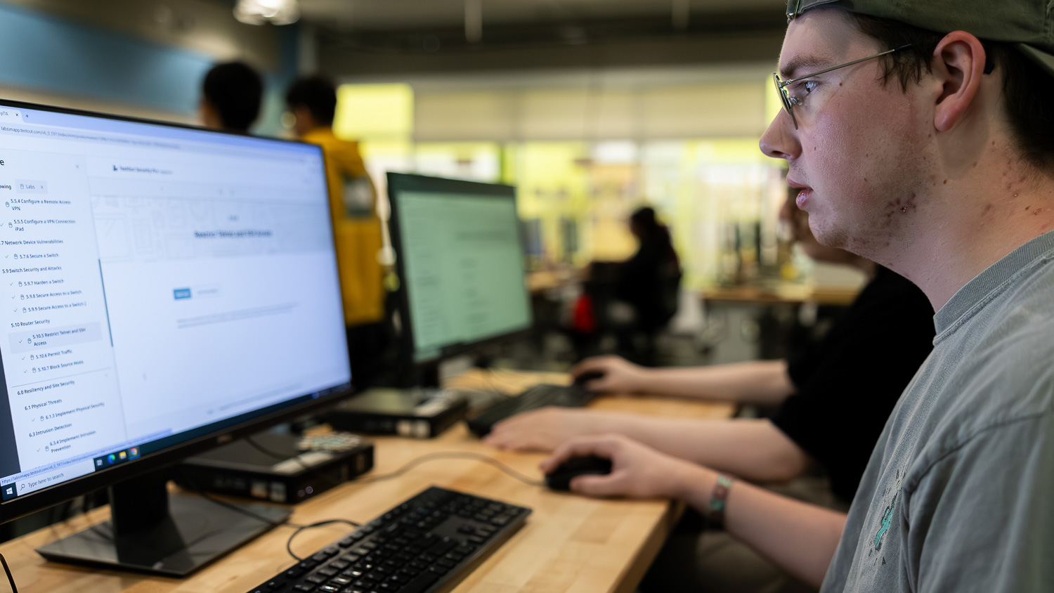 Cybersecurity student sitting and working on a computer.