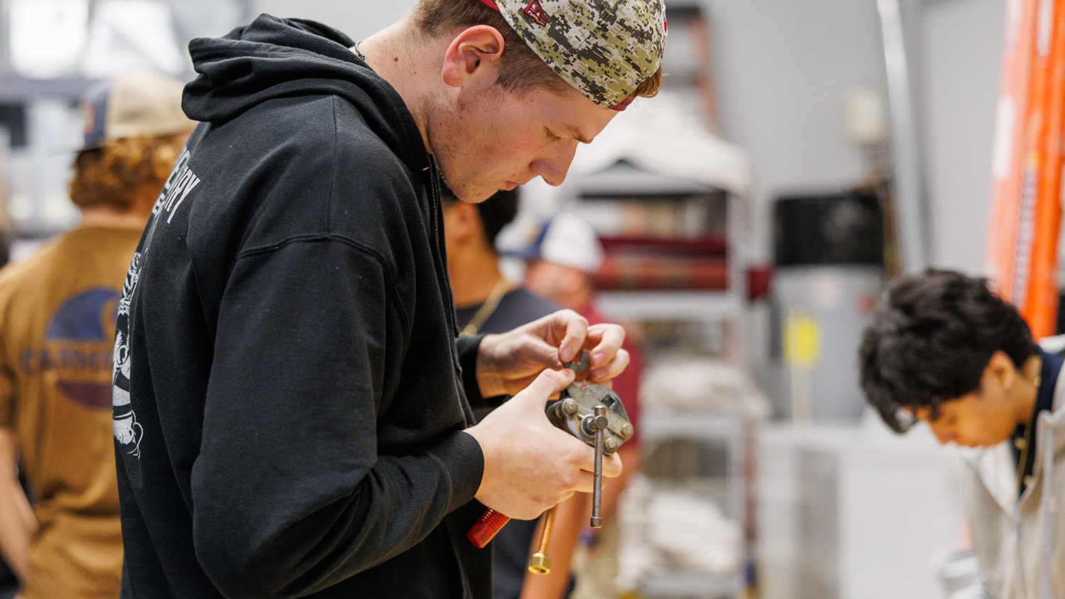 HVAC student using a tube bender to bend copper tubing.