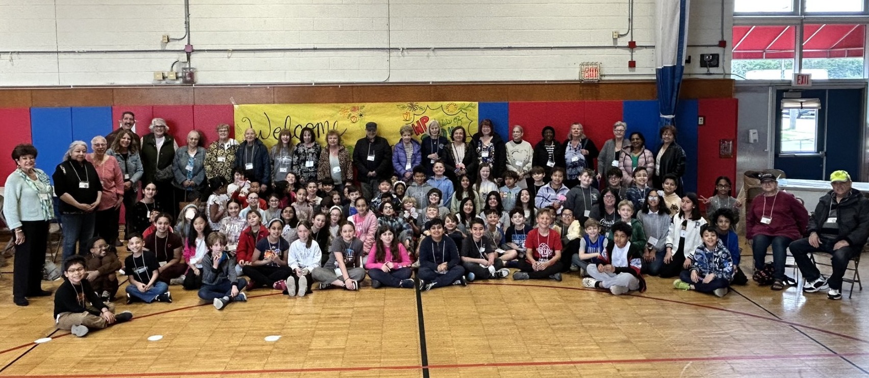 fourth grade students and seniors posing in the school gymnasium