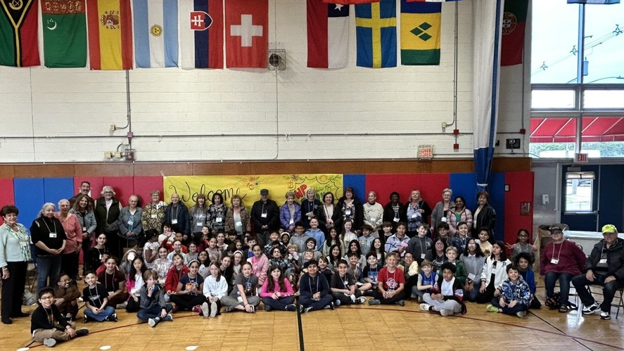 4th grade students and senior citizens in school gymnasium