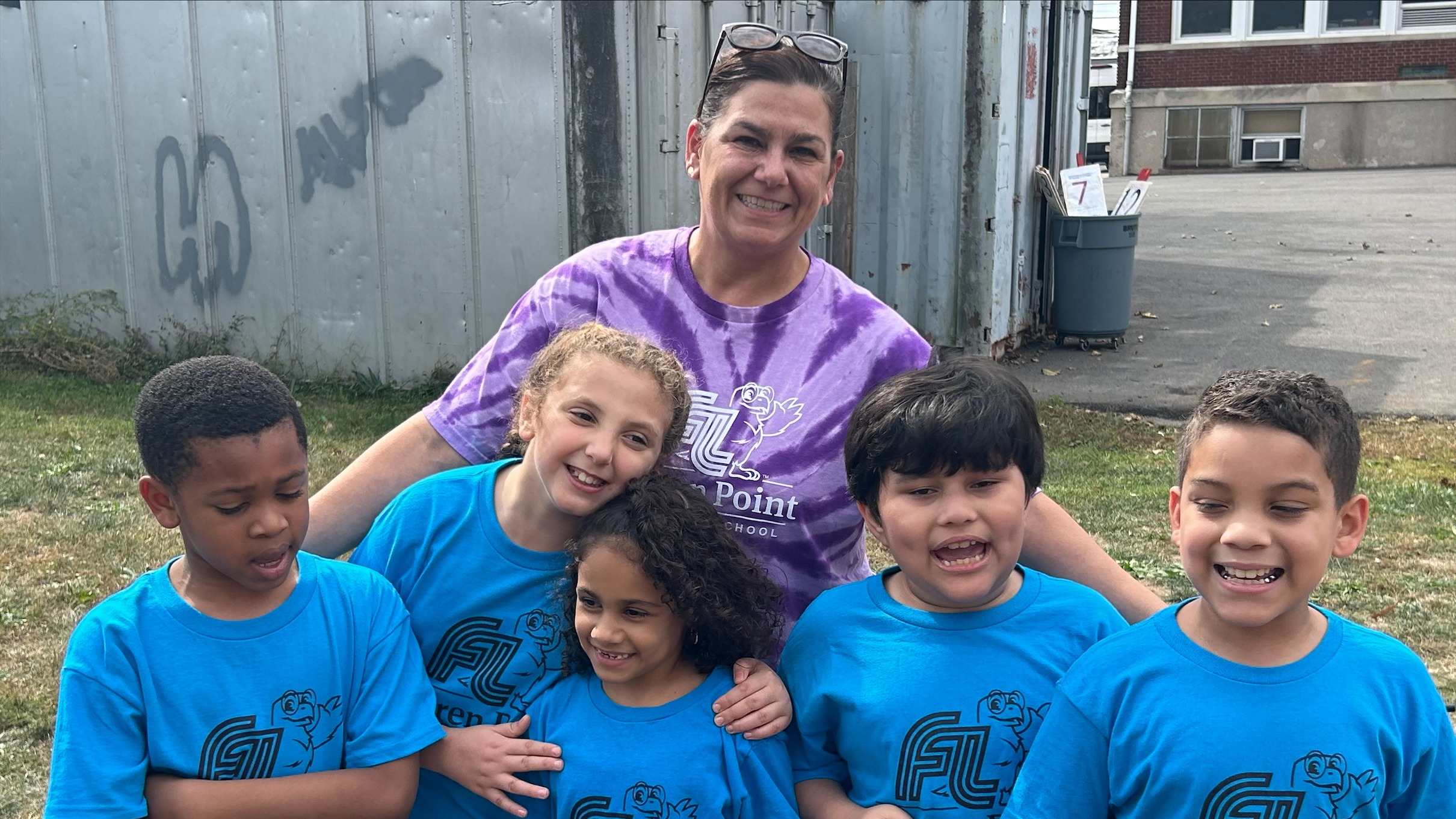principal standing  with 5 students at color games