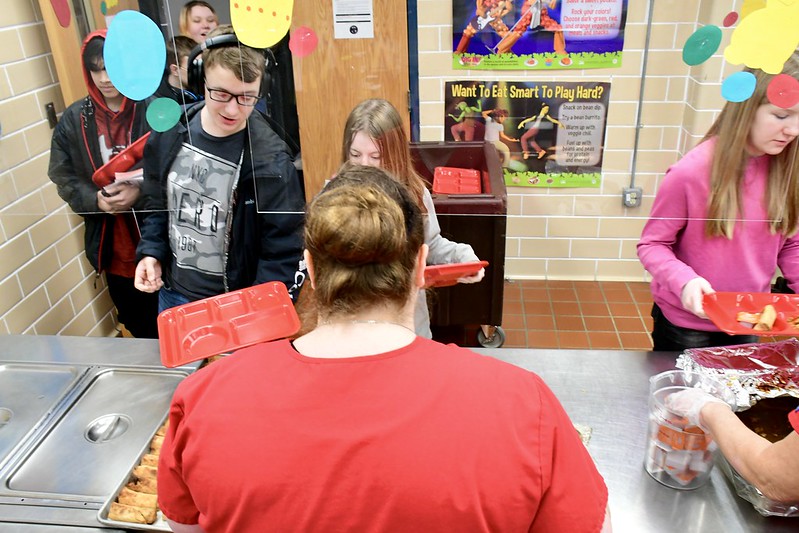 Students being served lunch by food service staff