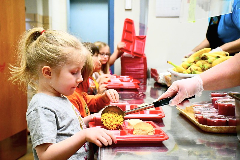 Student being served corn in the lunch line