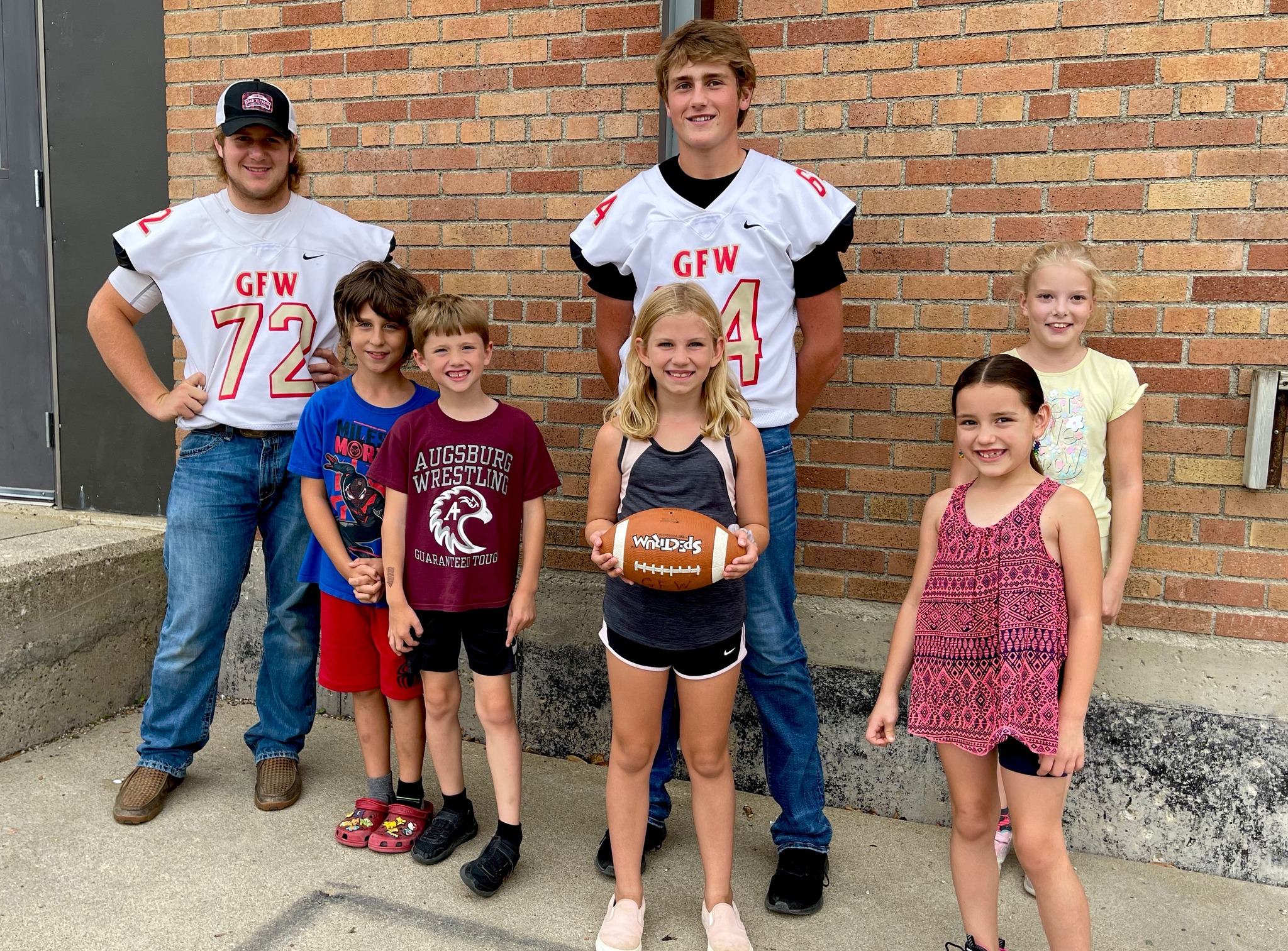 Football players with Elementary Students