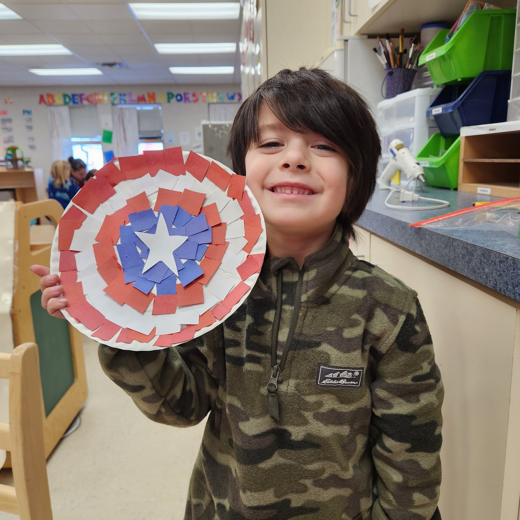 Student showing off a shield they made