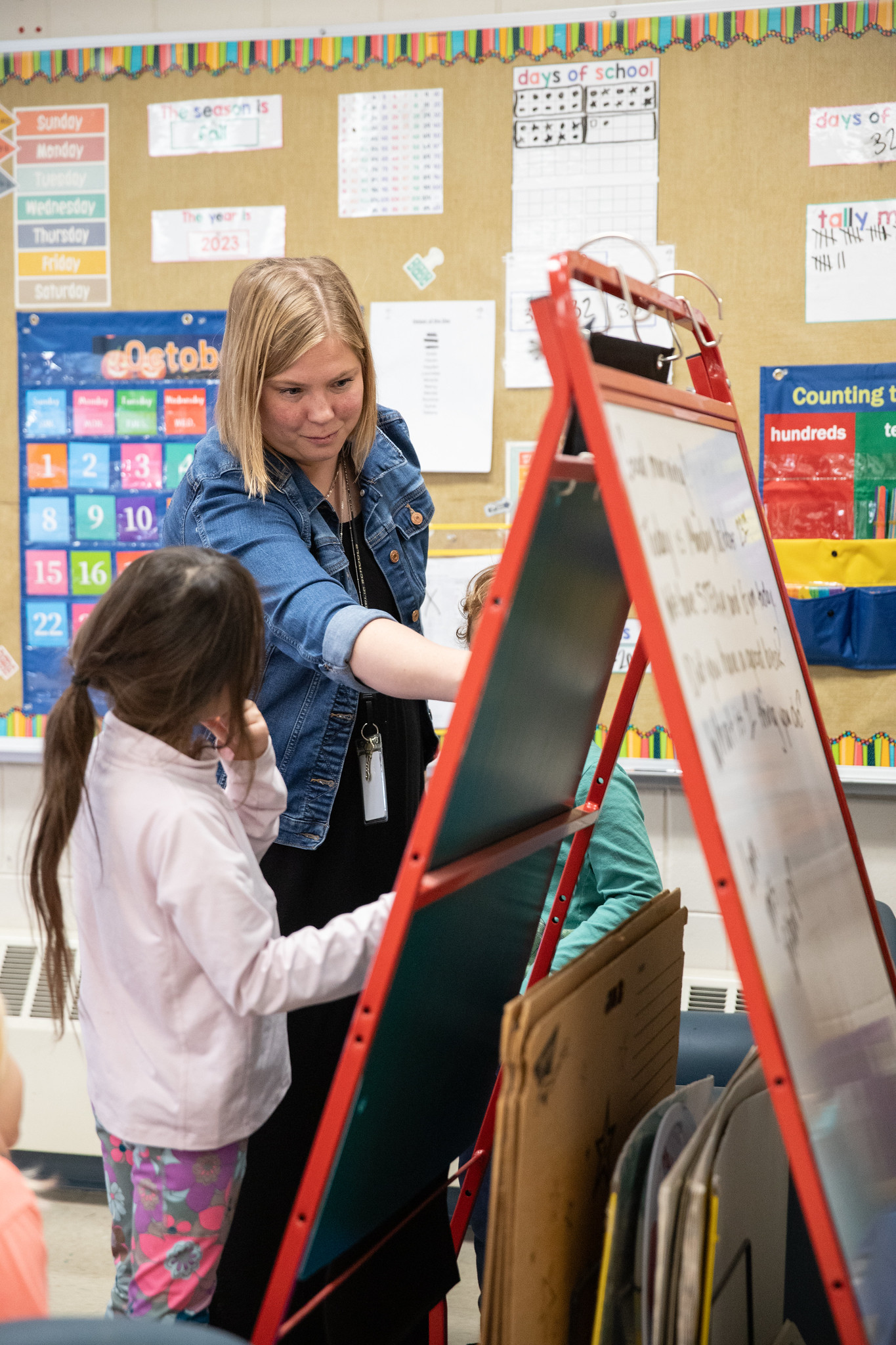 Teacher and student working at easel 