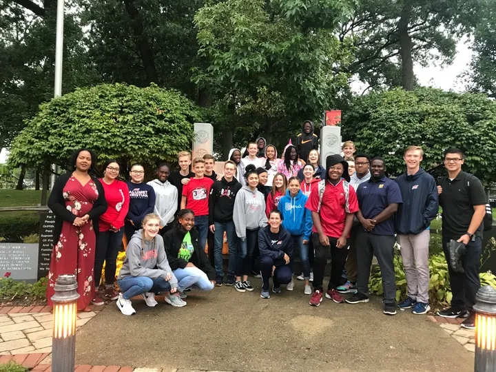 A group of people standing outside near trees