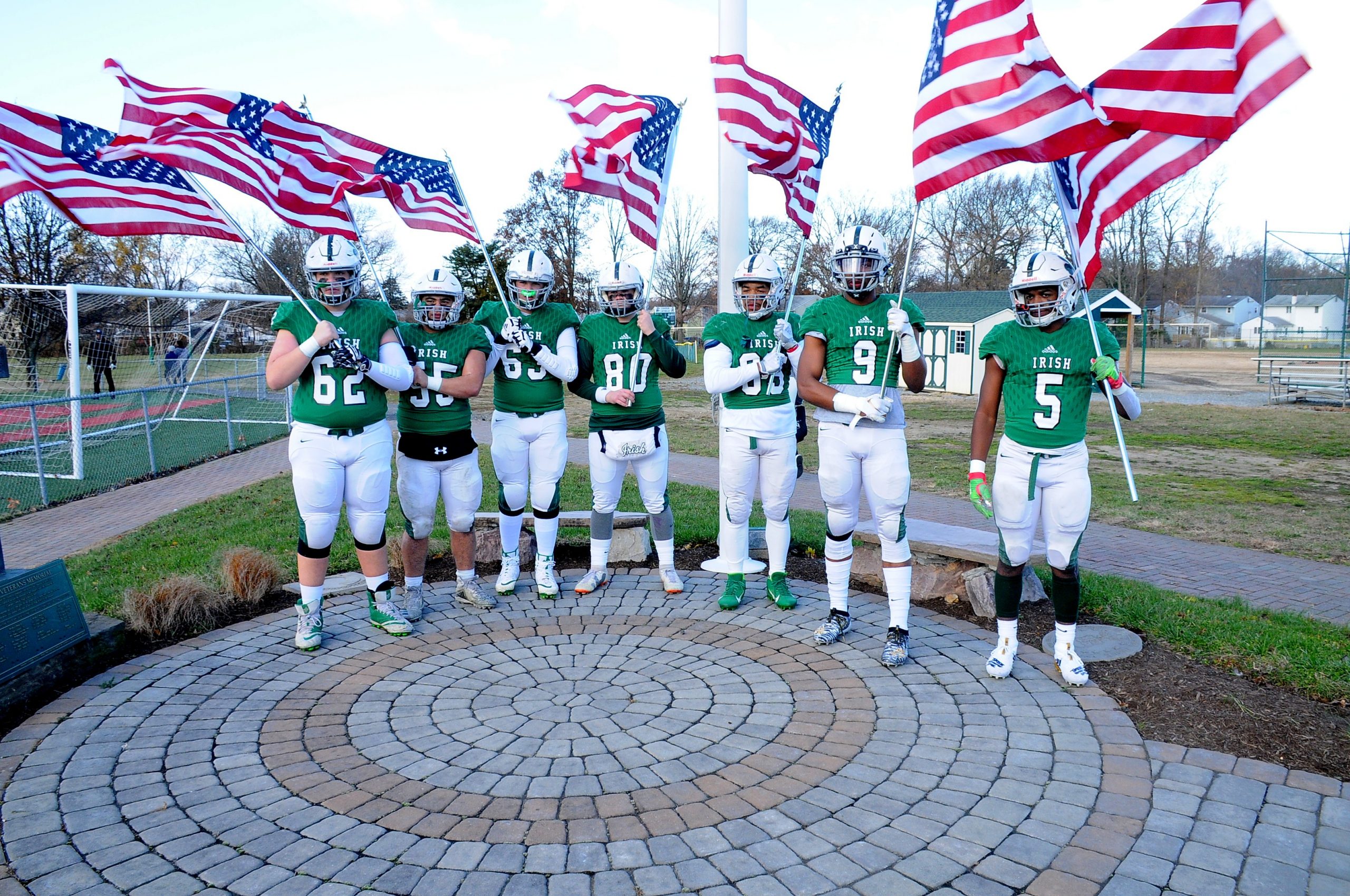 group picture of football team holding American flags