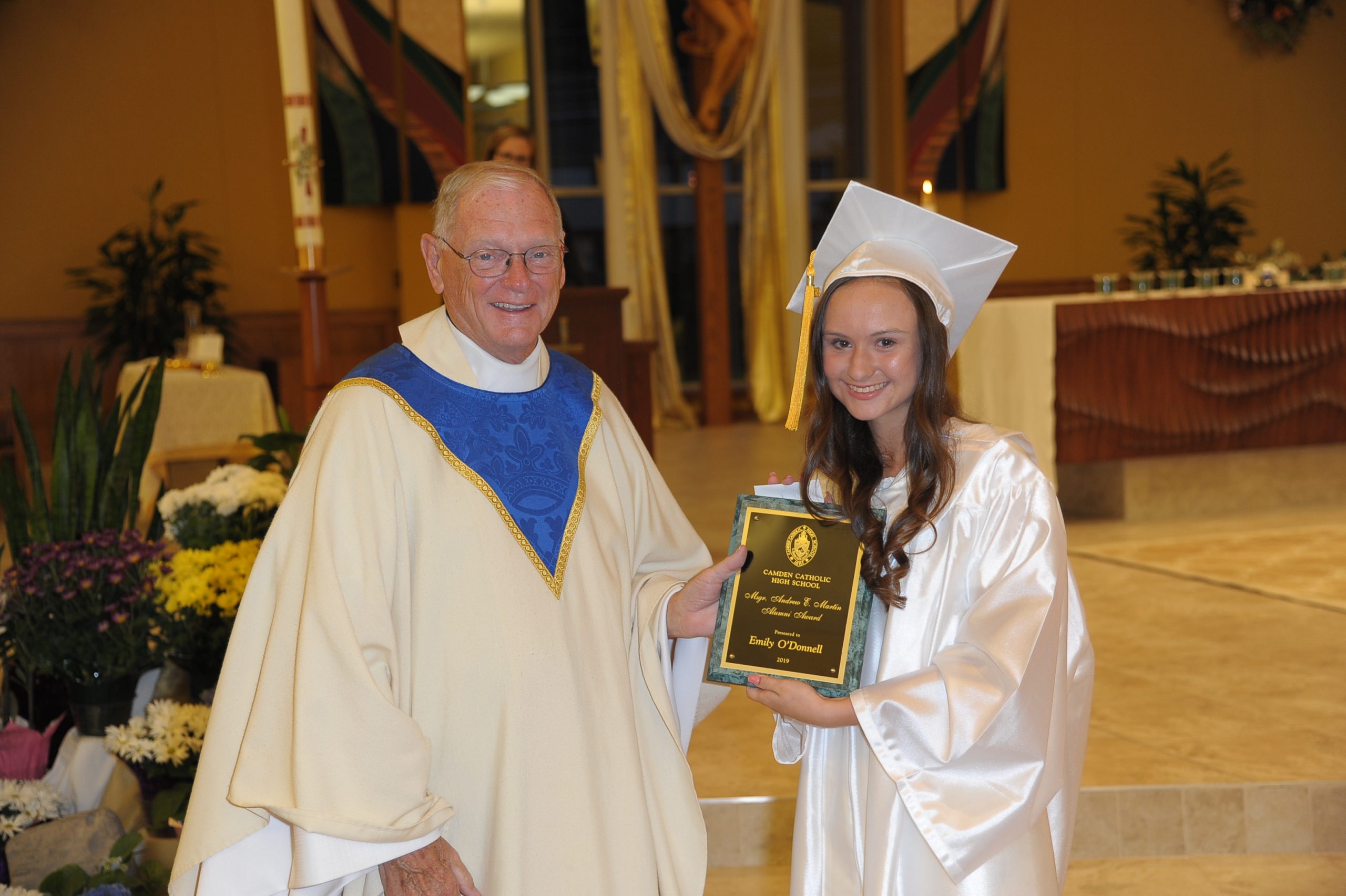 priest giving award to student